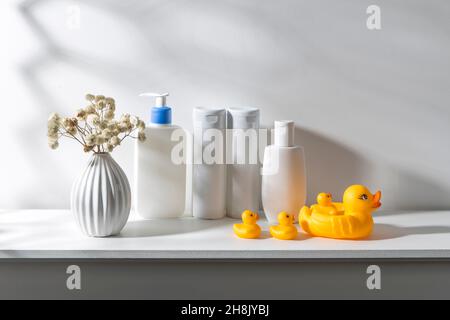 Regal im Badezimmer. Bouquet von Gypsophila in weißer gewellter Vase im Stil der siebziger Jahre, Flaschen Shampoo und Creme, kleine Gesichtstücher in CO Stockfoto