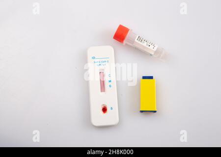 Isolierte Aufnahme einer Schnellexprimierungs-Antigenantikörper-Coronavirus Covid-19-Pandemietestprobe mit Blut, einer Lanzettenfläschchen und einer Lösung auf weißem Backgrou Stockfoto