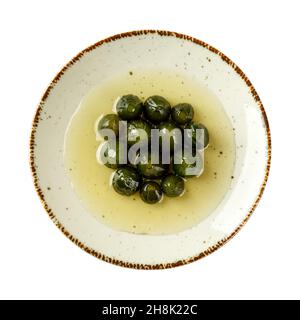 Köstliche ganze unreife Feigen in Sirup auf einem weißen Porzellanteller isoliert auf weißem Hintergrund. Leckere grüne Feigenmarmelade. Traditionelles mediterranes Dessert Stockfoto