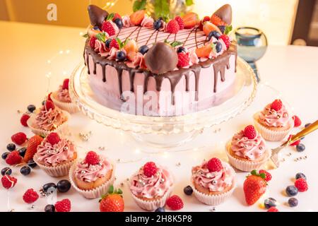 Nahaufnahme eines Erdbeerkuchens und ein paar Cupcakes auf einem Tisch Stockfoto