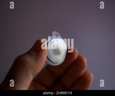 POV männliche Hand mit neuem Apple Computers AirTag-Gerät, um verlorene Gegenstände zu verfolgen Stockfoto