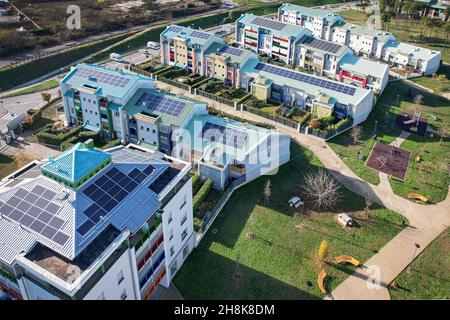 Moderne Häuser mit Sonnenkollektoren auf dem Dach für alternative Energien. Grugliasco, Italien - November 2021 Stockfoto
