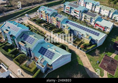 Moderne Häuser mit Sonnenkollektoren auf dem Dach für alternative Energien. Grugliasco, Italien - November 2021 Stockfoto
