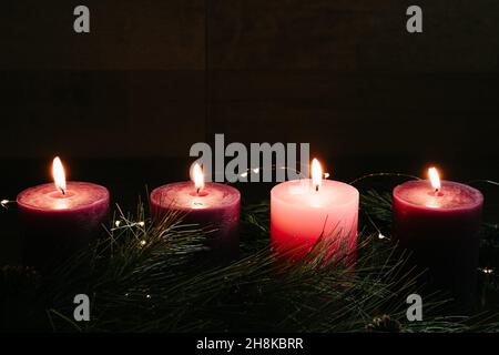 Vier Säulen-Kerzen zündeten in einem dunklen Raum für die vierte Adventswoche mit Kopierraum auf einem Adventskranz an Stockfoto