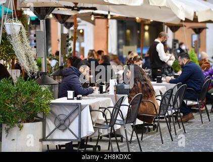 Rom, Italien. 30th. November 2021. Am 30. November 2021 sitzen Menschen auf der Terrasse eines Restaurants in Rom, Italien. Italien meldete am Dienstag 12.764 neue COVID-19-Fälle, was die Gesamtzahl der bestätigten COVID-19-Fälle nach den neuesten Daten des italienischen Gesundheitsministeriums auf 5.028.547 bringt. Quelle: Jin Mamengni/Xinhua/Alamy Live News Stockfoto