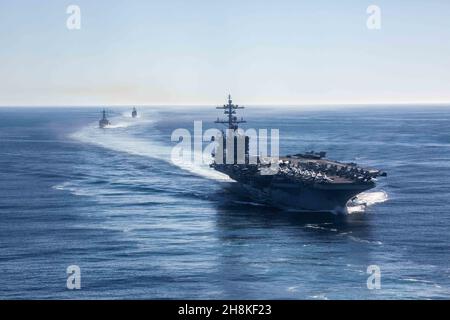 PAZIFISCHER OZEAN (Nov 13, 2021) USS Abraham Lincoln (CVN 72) (rechts), Arleigh Burke-Klasse Zerstörer USS Fitzgerald (DDG 62) (links) und Ticonderoga-Klasse Kreuzer USS Mobile Bay (CG 53), zugeordnet zu Carrier Strike Group (CSG) 3, segeln in Formation im Pazifischen Ozean. CSG-3 führt derzeit Routineoperationen in der US-3rd-Flotte durch. (USA Navy Foto von Mass Communication Specialist 3rd Class Lake Fultz/veröffentlicht) Stockfoto