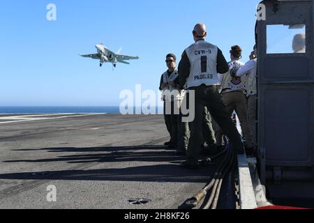 PAZIFISCHER OZEAN (Nov 13, 2021) Landing Signal Offiziere beobachten Flugoperationen, wie eine F/A-18E Super Hornet, zugewiesen an die „Vigilantes“ von Strike Fighter Squadron (VFA) 151, landet auf dem Flugdeck der USS Abraham Lincoln (CVN 72). Abraham Lincoln führt derzeit Routineoperationen in der US-Flotte von 3rd durch. (USA Navy Foto von Mass Communication Specialist 3rd Klasse Louis Lea/veröffentlicht) Stockfoto