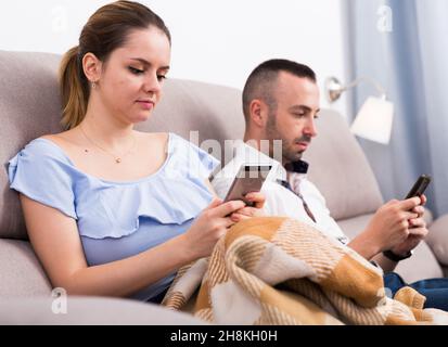 Verheiratetes Paar mit Mobiltelefonen Stockfoto