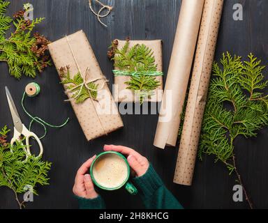 Eingewickelte Weihnachts-Geschenkschachteln in Bastelpapier mit Thuja-Zweigen Stockfoto