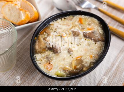 Suppe mit verschiedenen Pilzen, Gemüse und Schweinefleisch Stockfoto