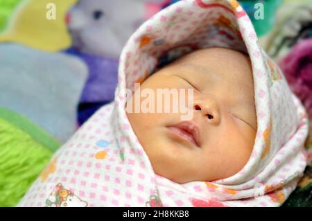 Ciamis, Indonesien - 28. September 2019 : Indonesische Neugeborene werden in ein Tuch gewickelt, um sie warm zu halten, Ciamis, West Java - Indonesien Stockfoto