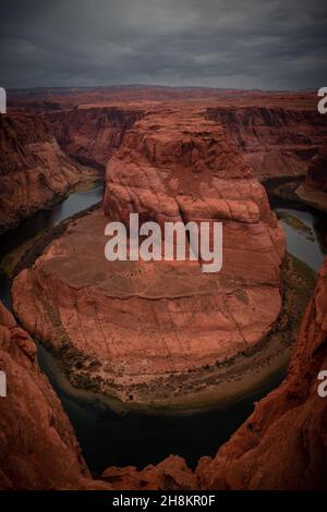 Blick auf das Horseshoe Bend, ein hufeisenförmiges, eingeschnitztes Mäander des Colorado River, Sturmwolken am Himmel, Page, Arizona, USA Stockfoto