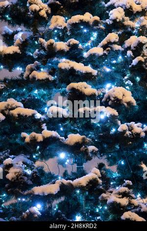 Weihnachtsbaum und Lichter vor dem rathaus von brackley im Abendschnee. Brackley, Northamptonshire, England Stockfoto