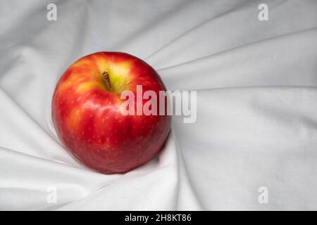 Ein roter Apfel auf weißem Tuch Stockfoto