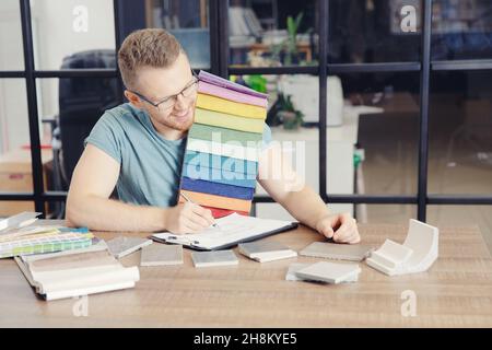 Schneider Designer wählt Polsterung für Sofa, Auswahl Farbe der Vorhänge Interieur des Hauses im Büro. Stockfoto