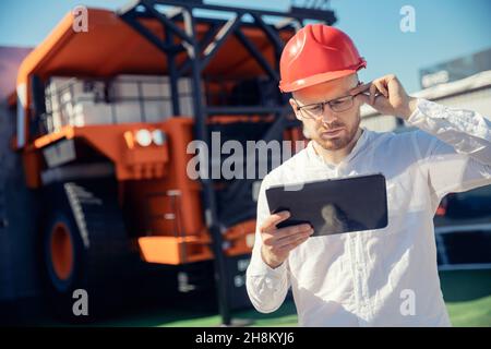 Junger Mann Vorarbeiter Überprüfung Protokolle in Tablet-Computer, Konzept offene Kohle Bergbau Industrie portret Arbeiter. Stockfoto