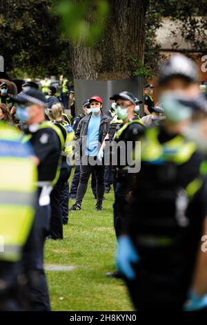 Ein Mann, der einen roten Hut von Victoria Great trägt, steht wieder umgeben von der Polizei, als er zusammen mit etwa 30 anderen Demonstranten $600 verhandelt und zu einer Geldstrafe verurteilt wird. Ein Protest des Premierministers des Bundesstaates Daniel Andrews in Treasury Gardens zog eine starke Reaktion der Polizei nach sich und ließ die Demonstranten am Samstag im zentralen Geschäftsviertel von Melbourne von Polizisten der öffentlichen Ordnung und der allgemeinen Pflichten nummerieren. (Foto von Michael Currie/Speed Media) Stockfoto