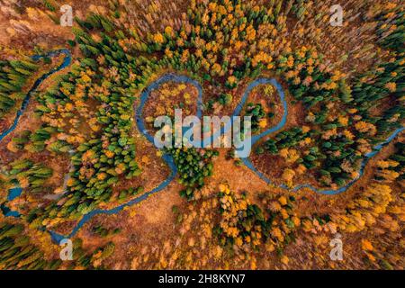 Herbstwaldlandschaft bei Sonnenuntergang mit gewundener Fluss zwischen Hügeln, Luftaufnahme von oben. Stockfoto