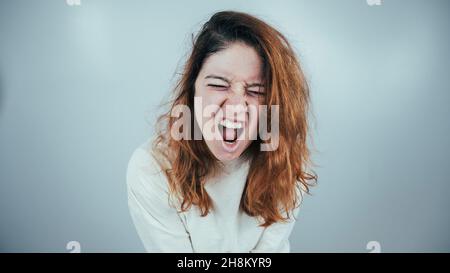 Nahaufnahme Porträt einer verrückten Frau in Zwangsjacke auf weißem Hintergrund. Stockfoto