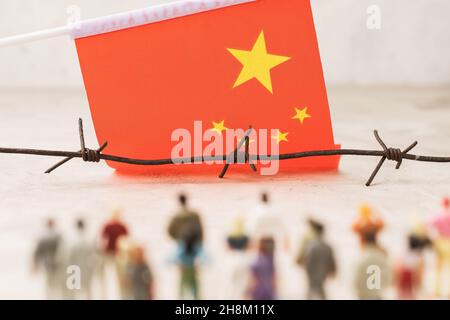 China-Flagge, Stacheldraht und Plastikspielzeug Männer, illegale Migration Konzept Stockfoto