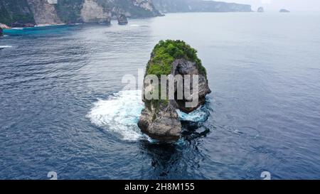 Natürlicher Felsbogen im Indischen Ozean, in der Nähe der Wild Coast auf Nusa Penida Island, Bali. Das große offene Loch an der Seite der Klippe wird von Wellen geformt. Wenn die Stockfoto