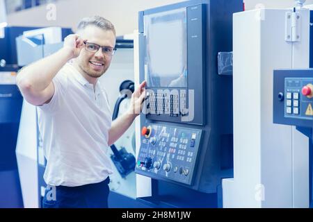 Konzept glücklich Ingenieur Industrie Metall-Werkstatt. Industriearbeiter Operator verwenden automatisierte CNC-Drehmaschine auf automatischer moderner Fabrikhalle. Stockfoto