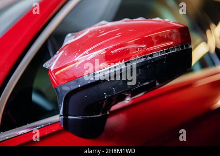 Meister Mann installiert Vinyl-Folie schützen Farbe Körper Seitenspiegel Auto. Stockfoto