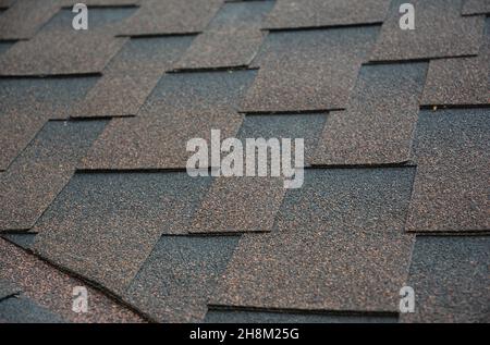 Eine Nahaufnahme eines offenen Dachtals, das mit Asphaltschindeln bedeckt ist. Abdichtung Dachbereich Problem, die Dachundichtigkeiten verursachen können. Stockfoto
