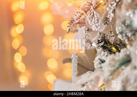 Nahaufnahme dekoriert weißen Weihnachtsbaum auf gelben Lichtern verschwommener Hintergrund Stockfoto
