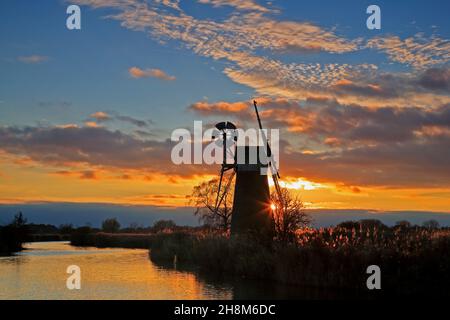 Ein Blick auf einen bunten Sonnenuntergang im Herbst über dem Fluss Ant auf den Norfolk Broads von Turf Fen Drainage Mill aus Ludham, Norfolk, England, Großbritannien. Stockfoto