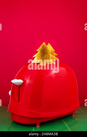 Roter Toaster knusprig frischer Toast Tannenbaum auf grünen Fliesen. Frühstück. Morgen Brot Scheibe Sandwich Kochen kreative Minimalismus Idee Weihnachten s Stockfoto