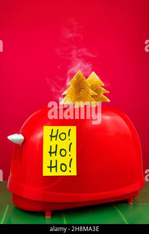 Roter Toaster knusprig frischer Toast Tannenbaum Form grüne Fliesen. Frühstück. Morning Bread Slice Sandwich kreativ Minimalismus Idee Ho Ho Ho gelb sticke Stockfoto