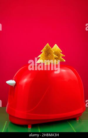 Roter Toaster knusprig frischer Toast Tannenbaum auf grünen Fliesen. Frühstück. Morgen Brot Scheibe Sandwich Kochen kreative Minimalismus Idee Weihnachten s Stockfoto