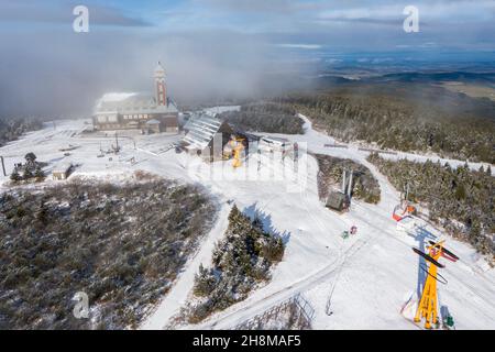 Oberwiesenthal, Deutschland. 23rd. November 2021. Eine dünne Schneeschicht liegt auf dem Gipfel des Fichtelbergs. Neben dem Fichtelberghaus ist die Seilbahn-Station zu sehen. (Luftaufnahme mit Drohne) Quelle: Jan Woitas/dpa-Zentralbild/dpa/Alamy Live News Stockfoto