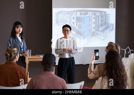 Asiatische erfolgreiche Geschäftsfrau spricht über das neue Architekturprojekt während der Präsentation für Geschäftsleute Stockfoto