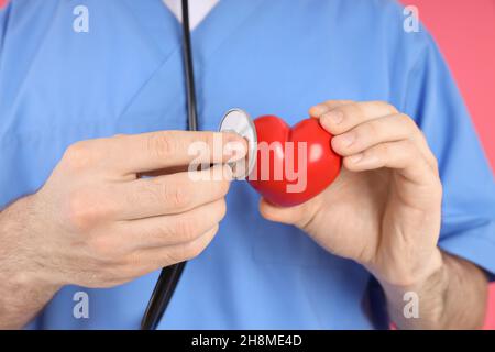 Krankenschwester Mann hält rotes Herz, Nahaufnahme Stockfoto