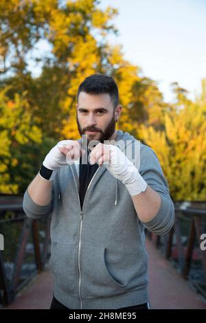Porträt des kaukasischen männlichen Boxers mit Bart in Outdoor-Sportbekleidung Stockfoto