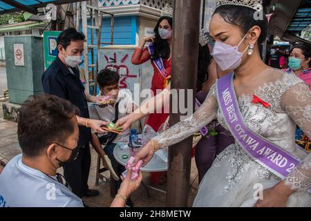 Bangkok, Thailand. 01st Dez 2021. Die Menschen erhalten Kondome von Panurat Noibunjong 'Miss LGBT Thailand Friendship 2021' während der Kampagnen zum Welt-Aids-Tag 2021. Zum Welt-Aids-Tag 2021 wurden im Bezirk Ratchathewi, Bangkok, am Siegesdenkmal anlässlich des Welt-Aids-Tages 2021 Kampagnen durchgeführt. Das Thema des Welt-Aids-Tages 2021 der Weltgesundheitsorganisation (WHO) lautet „Beseitigung von Ungleichheiten. End AIDS“. „mit einem besonderen Fokus darauf, die zurückgelassenen Menschen zu erreichen und die wachsenden Ungleichheiten beim Zugang zu wichtigen HIV-Dienstleistungen hervorzuheben. Kredit: SOPA Images Limited/Alamy Live Nachrichten Stockfoto