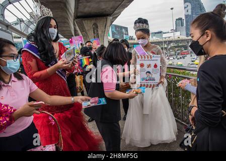 Die Menschen erhalten Kondome von Panurat Noibunjong 'Miss LGBT Thailand Friendship 2021' während der Kampagnen zum Welt-Aids-Tag 2021. Zum Welt-Aids-Tag 2021 wurden im Bezirk Ratchathewi, Bangkok, am Siegesdenkmal anlässlich des Welt-Aids-Tages 2021 Kampagnen durchgeführt. Das Thema des Welt-Aids-Tages 2021 der Weltgesundheitsorganisation (WHO) lautet „Beseitigung von Ungleichheiten. End AIDS“. „mit einem besonderen Fokus darauf, die zurückgelassenen Menschen zu erreichen und die wachsenden Ungleichheiten beim Zugang zu wichtigen HIV-Dienstleistungen hervorzuheben. (Foto von Peerapon Boonyakiat/SOPA Images/Sipa USA) Stockfoto