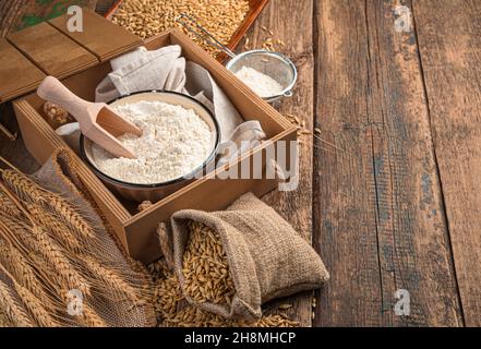 Mehl-, Weizen- und Weizenspikeletts auf einem hölzernen Hintergrund. Seitenansicht, Kopierbereich. Stockfoto