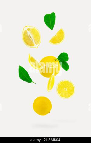 Saftig reife fliegende gelbe Zitronen mit Blättern. Set von fallenden leckeren Zitronen auf weißem Hintergrund, Zitrus minimal Konzept, Vitamin C Stockfoto