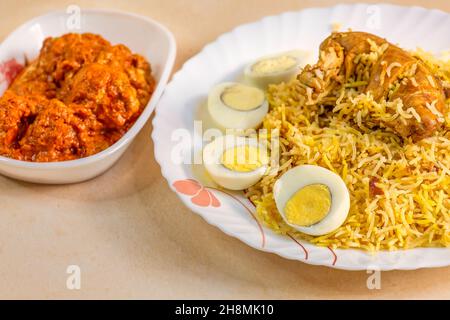 Würzige indische Biryani mit Hühnerkeule und in Scheiben geschnittenen Eiern in Nahaufnahme Stockfoto