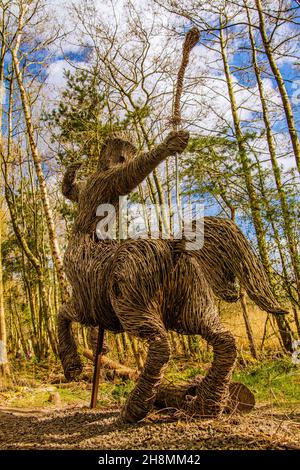 Die Centaur Archer Statue, aus Wicker gefertigt und in einem kleinen Wald im Kelpies, Helix Park, Falkirk, Schottland, Großbritannien, zu finden Stockfoto