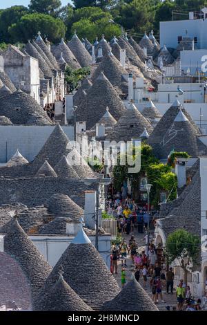 ALBEROBELLO, ITALIEN, 19. AUGUST 2021: Touristen in Alberobello, einer Stadt mit typischen Häusern, die in Apulien, Süditalien, als Trulli bezeichnet werden Stockfoto