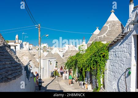 ALBEROBELLO, ITALIEN, 19. AUGUST 2021: Touristen in Alberobello, einer Stadt mit typischen Häusern, die in Apulien, Süditalien, als Trulli bezeichnet werden Stockfoto