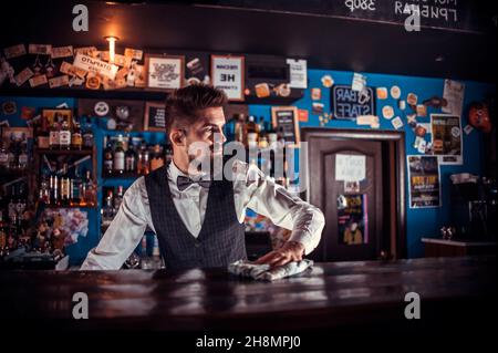 Bärtiger Barkeeper beendet intensiv seine Kreation Stockfoto
