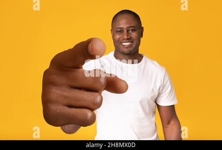 Glücklich reifen afroamerikanischen Kerl zeigt auf Kamera mit großer Hand über orangen Studio-Hintergrund Stockfoto