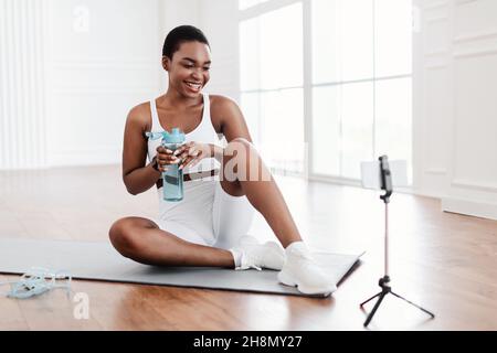 Junge schwarze Frau Frau mit Handy Aufnahme Tutorial Stockfoto