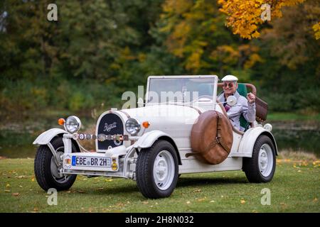 Ein älterer Herr, der in seinem Nachbau eines 1923-Jahre-Oldtimer-Autos des Typ 35 B, Markt Schwaben, Bayern, Deutschland, sitzt Stockfoto