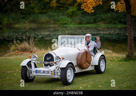 Ein älterer Herr, der in seinem Nachbau eines 1923-Jahre-Oldtimer-Autos des Typ 35 B, Markt Schwaben, Bayern, Deutschland, sitzt Stockfoto